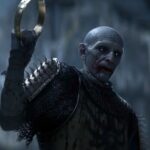 Блідий воїн у темних обладунках підіймає металеве кільце в The Blood of Dawnwalker